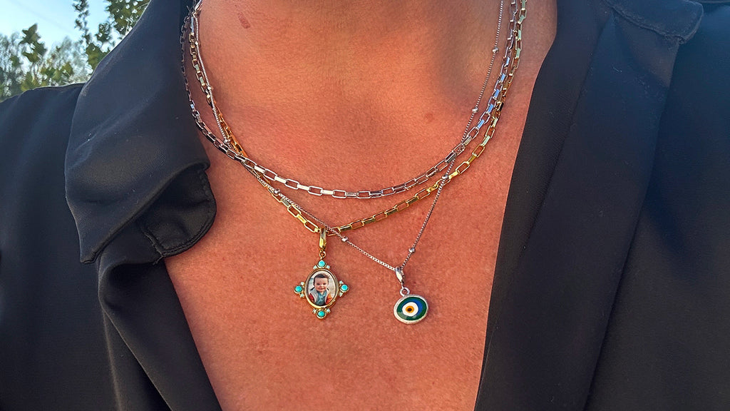 Woman wearing gold and silver - mixed metals necklace with portrait charm and evil eye