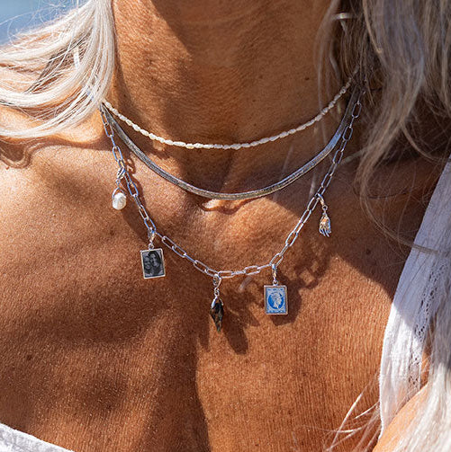 Woman wearing silver pearl charm on necklace
