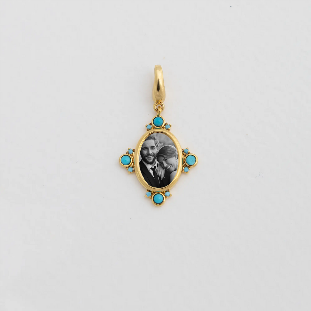 Gold oval locket pendant with a black and white photo of a smiling couple